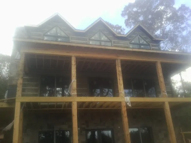 Dormers and porch framing on a large log home under construction — Roof Coating work by our crew in Dorchester